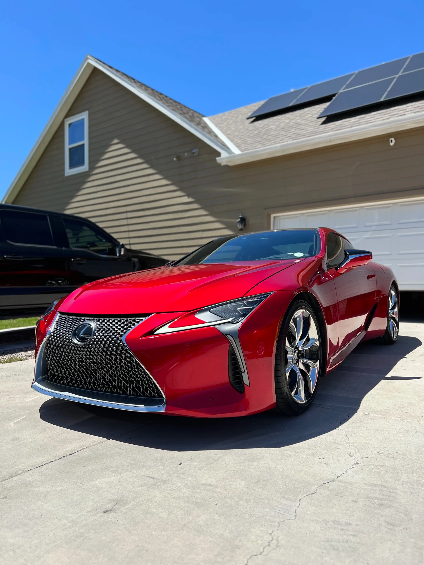 Red Lexus coupe with a glossy ceramic-coated finish parked in the sun after detailing