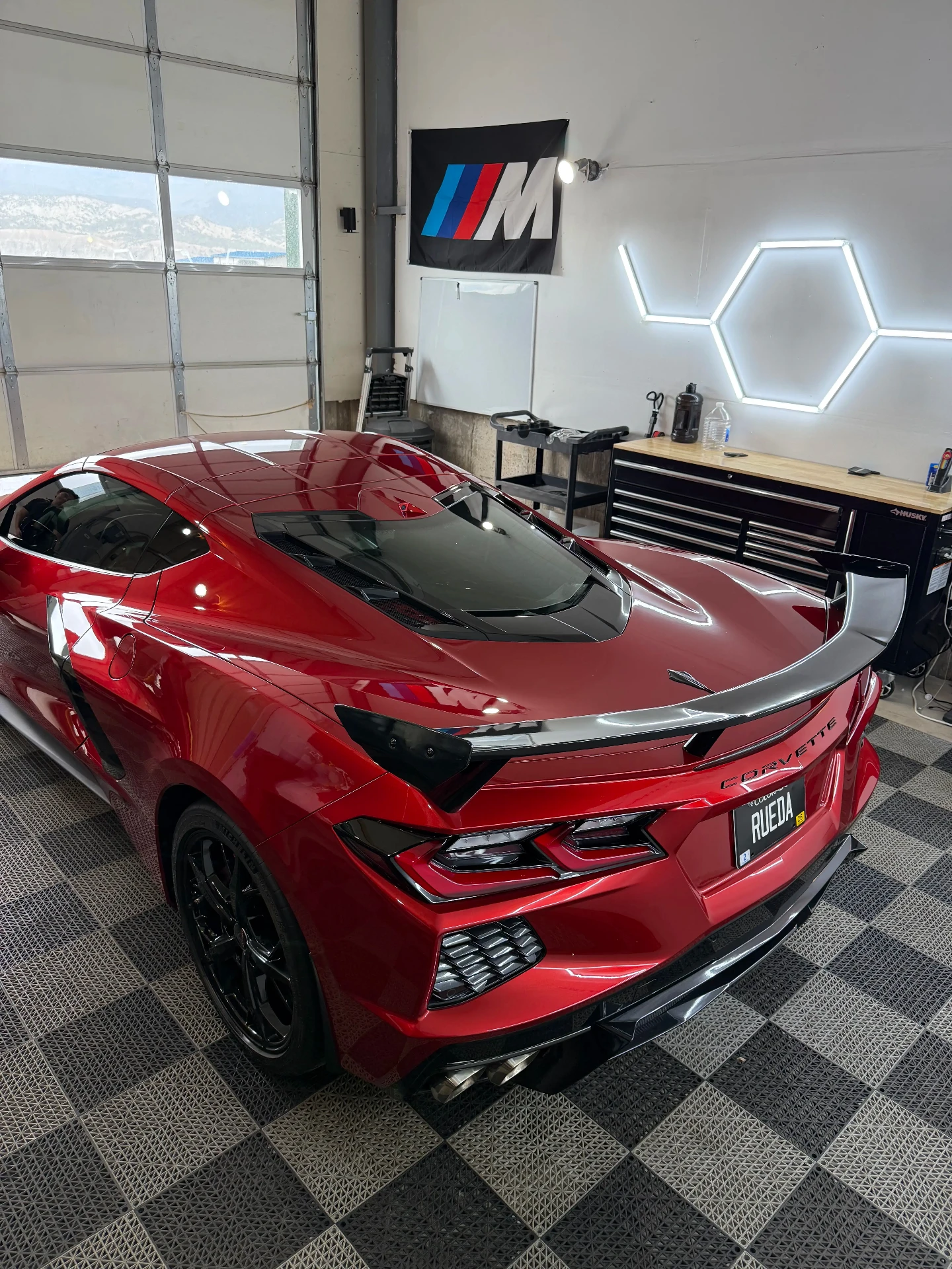 Red Chevrolet Corvette photographed from the rear inside the Deluxe Detailing studio after a ceramic coating