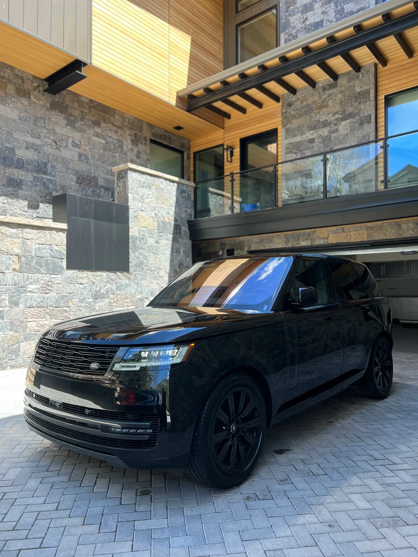 Black Range Rover with a deep gloss finish parked at a Colorado mountain home after ceramic coating
